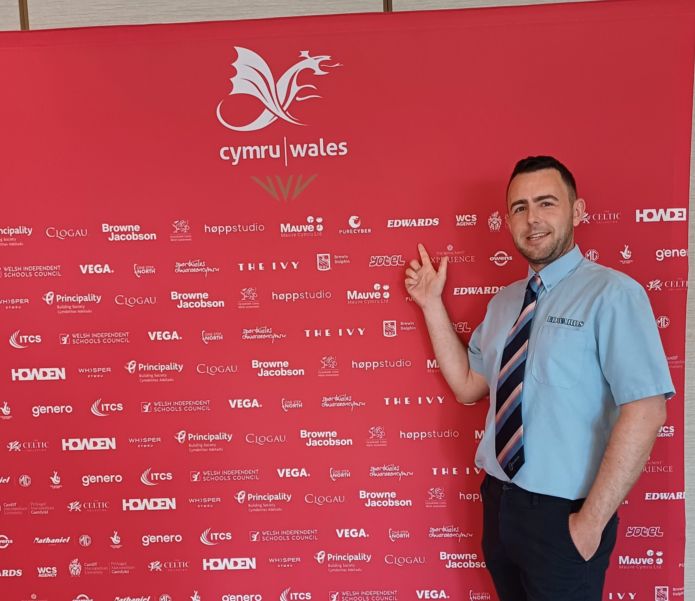 Edwards' Manager Simon Ingham pointing at the Team Wales logo